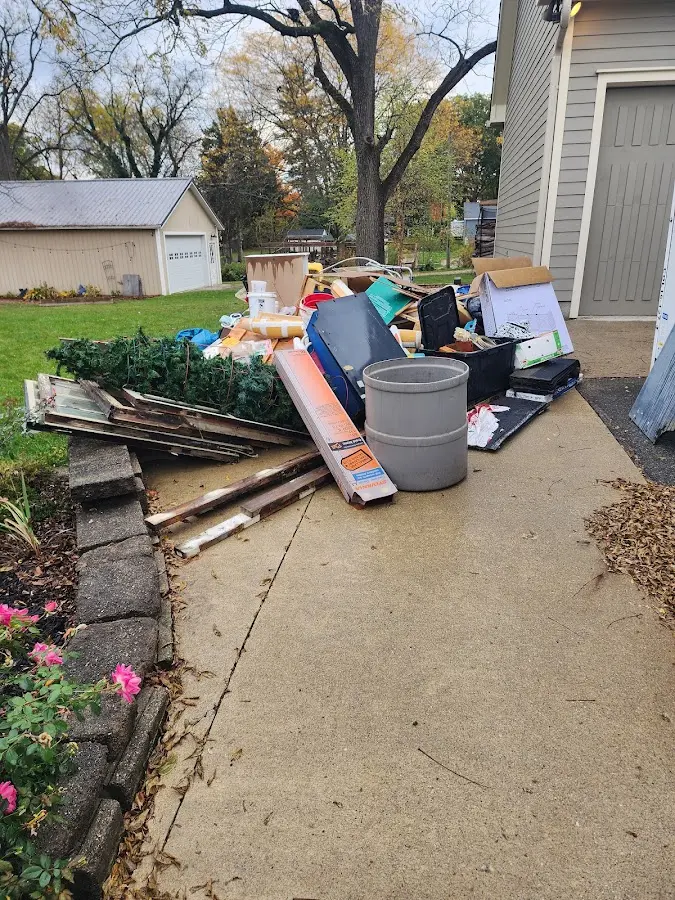 Dumpster being loaded with debris for Estate Cleanout Dumpster Rental in Waukon